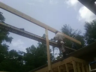 Carpenter setting a ridge beam over a new addition frame — Ice Dam Removal by Roofing Brothers in Rising Fawn