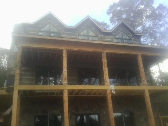Dormers and porch framing on a large log home under construction — Roof Coating work by our crew in Rising Fawn