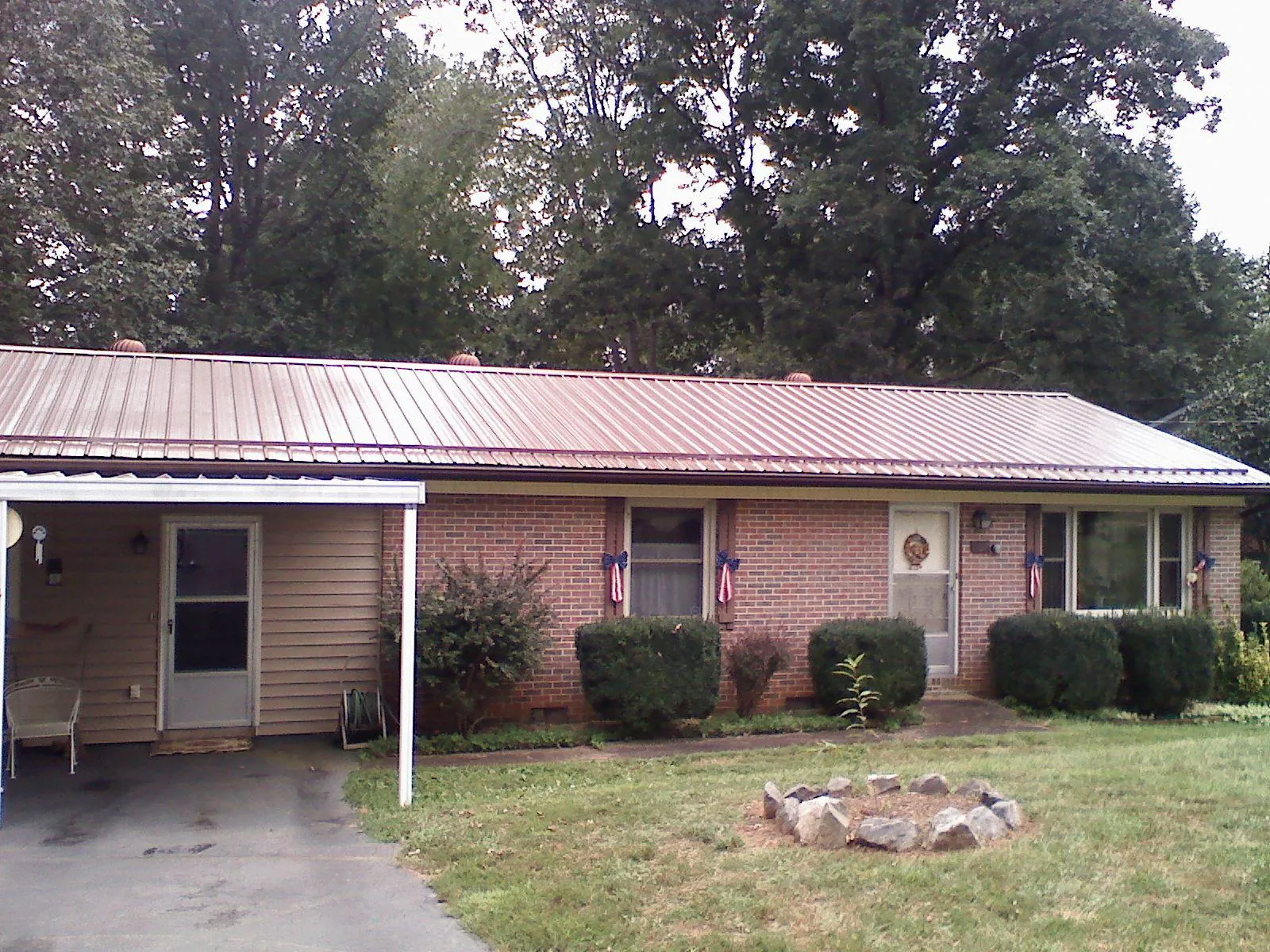 Bronze metal roof and carport on a brick ranch home — Roof Repair work by our crew in Rising Fawn